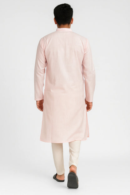 Person wearing a lucknowi chikankari light pink kurta with white pants on a white background
