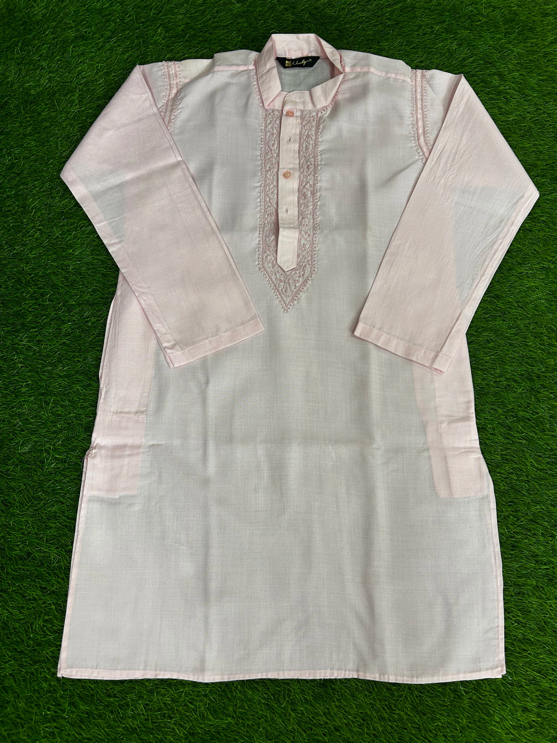 Light-colored kurta with embroidery on a green background