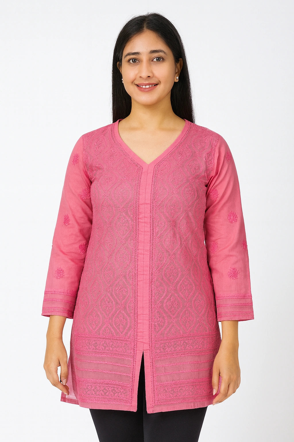 Woman wearing a pink embroidered top on a white background