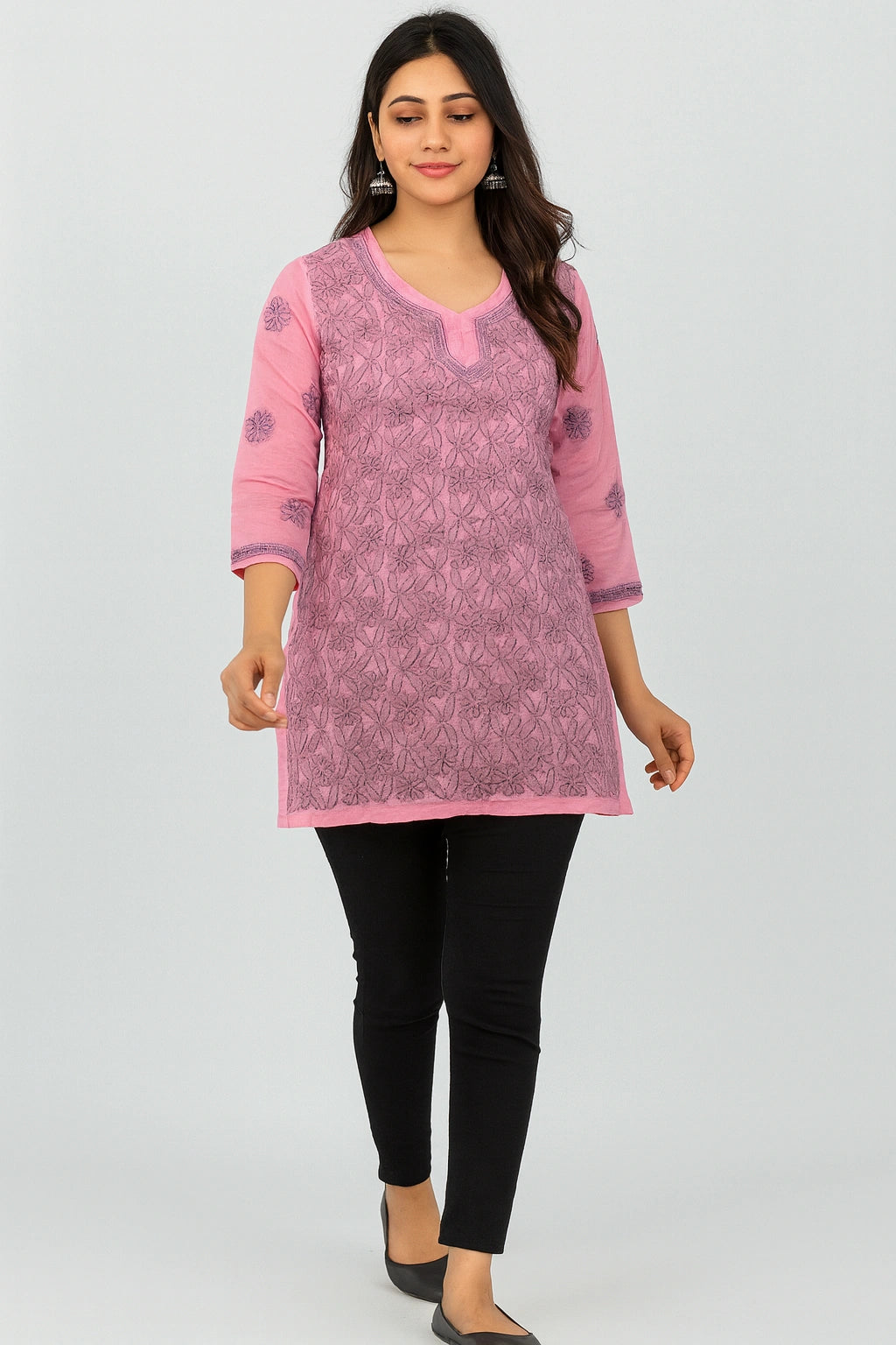 Woman wearing a lucknowi chikankari pink and black patterned kurta with black pants on a white background
