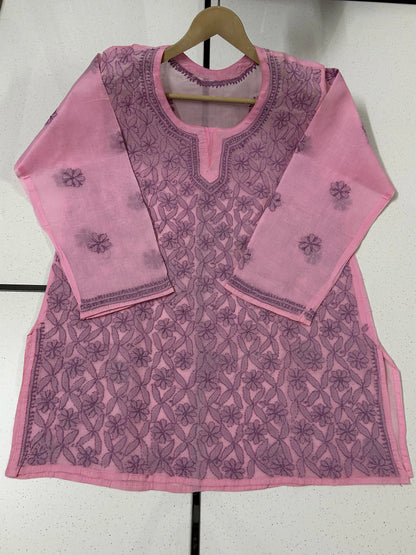 Pink embroidered top on a hanger against a white background