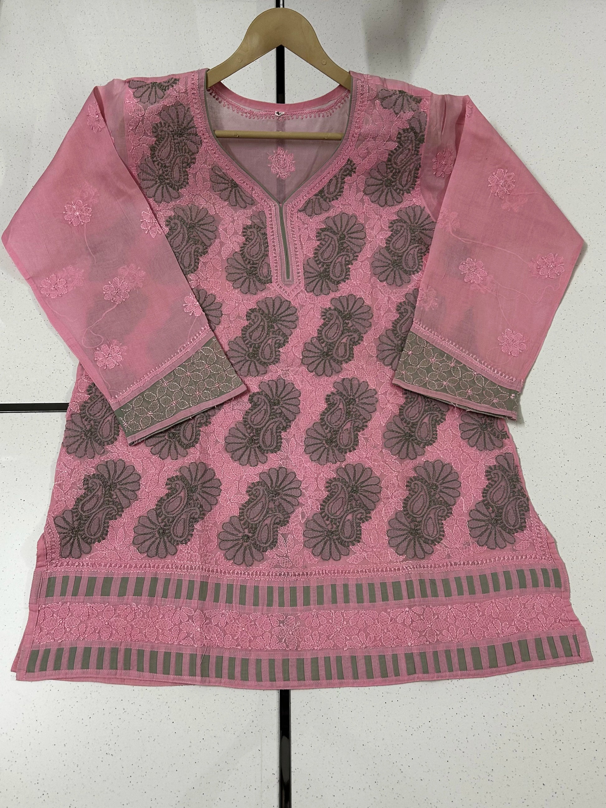 Woman wearing a lucknowi chikankari pink and green patterned kurta on a white background