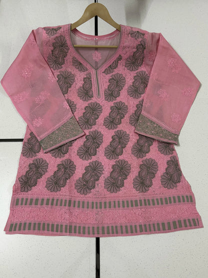 Woman wearing a lucknowi chikankari pink and green patterned kurta on a white background