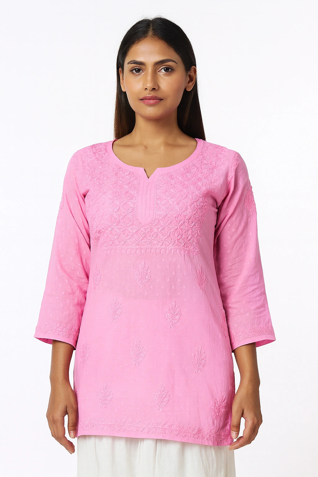Woman wearing a pink embroidered top on a white background