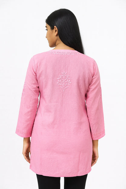 Woman wearing a pink embroidered kurta on a white background