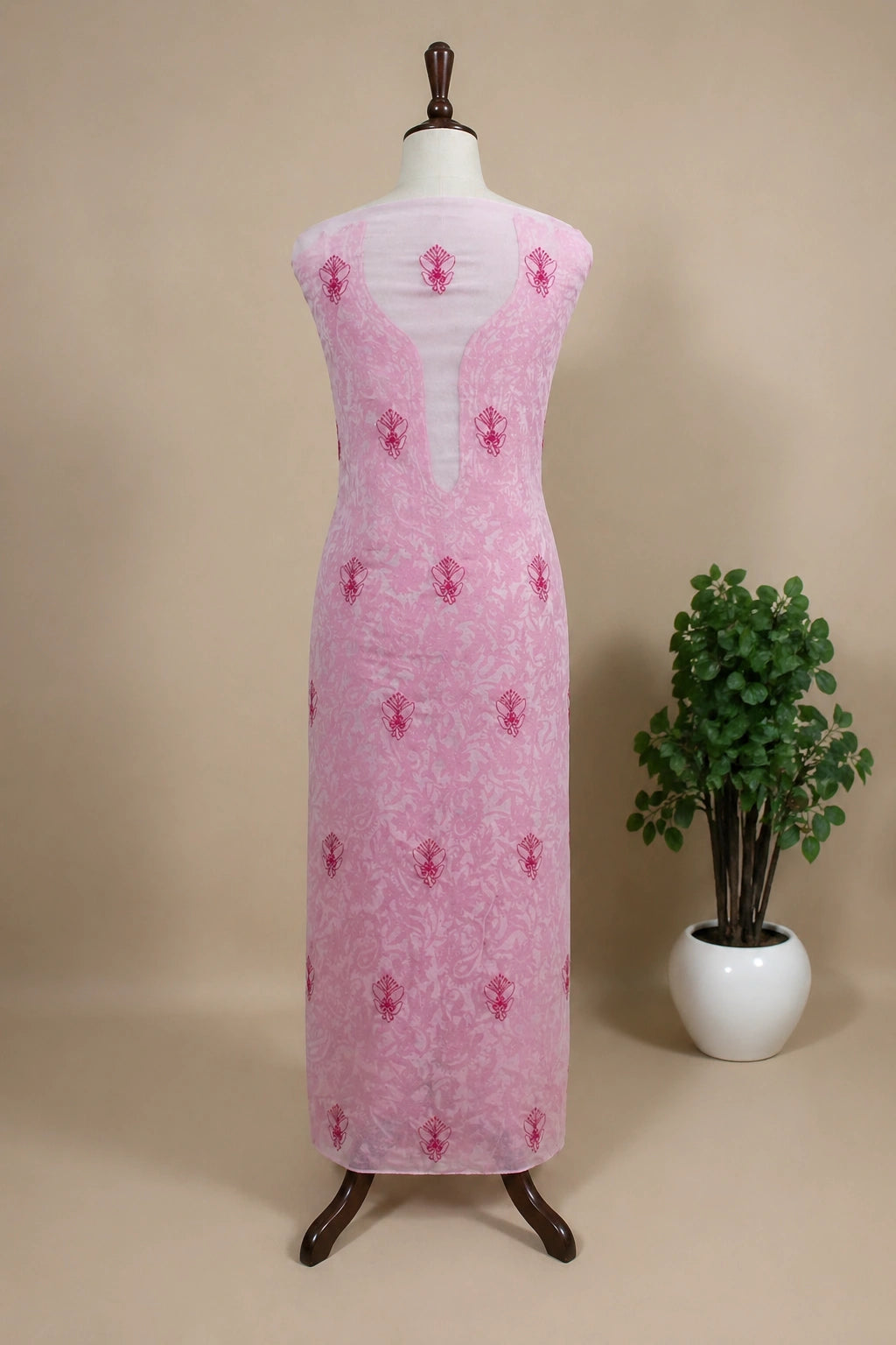 lucknowi chikankari Pink dress on a mannequin with a plant in the background