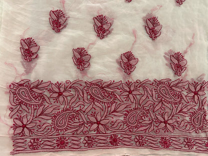 Embroidered fabric with red floral and paisley patterns on a white background