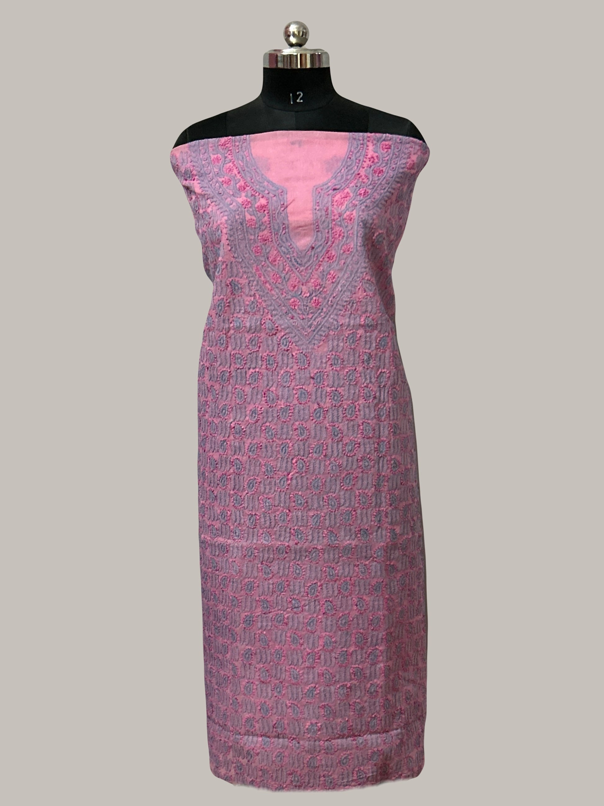 Mannequin wearing a pink and purple patterned dress on a plain background