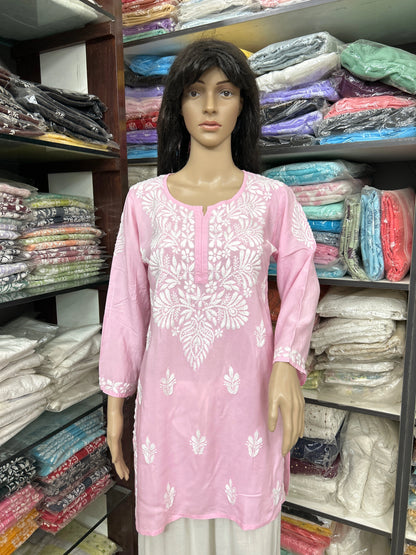 Mannequin wearing a pink embroidered kurta in a fabric store.