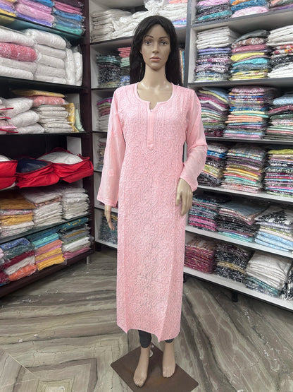 A pink long-sleeve kurta displayed on a female mannequin in a clothing store. The kurta features a textured, embroidered pattern and a small keyhole cutout at the neckline.
