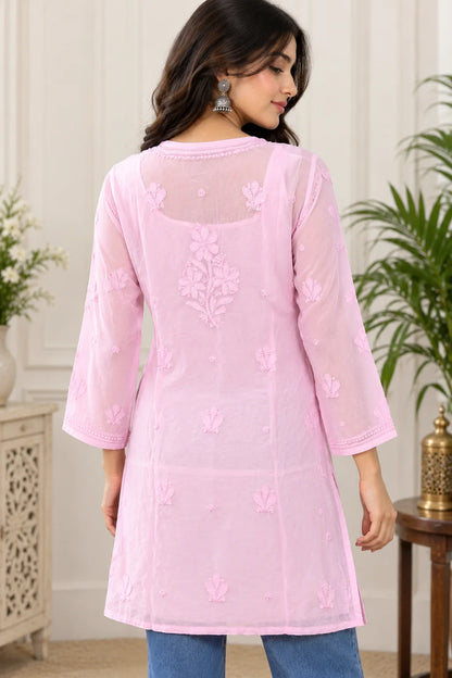 Woman wearing a lucknowi chikankari pink-colored kurta with white floral patterns