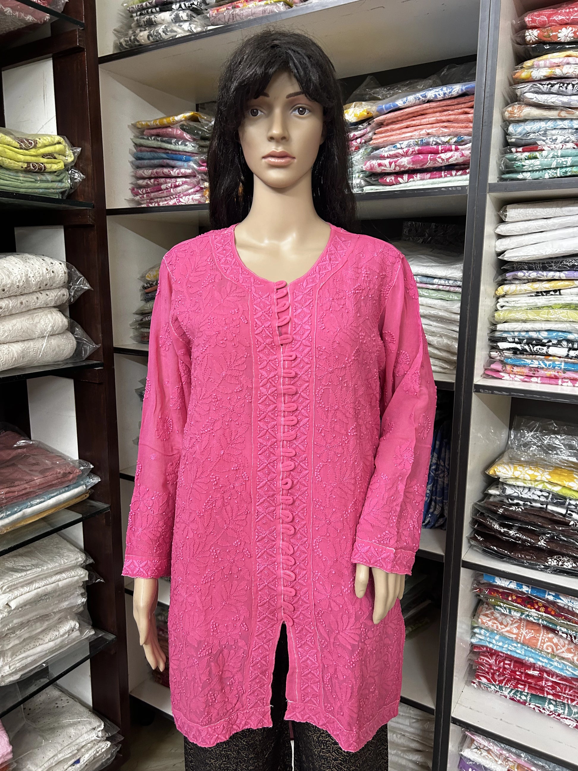 Mannequin wearing a lucknowi chikankari pink knitted sweater in a fabric store