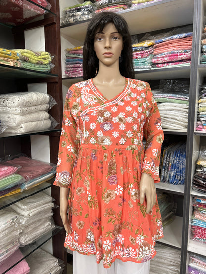 Mannequin wearing a lucknowi chikankari floral orange dress in a fabric store