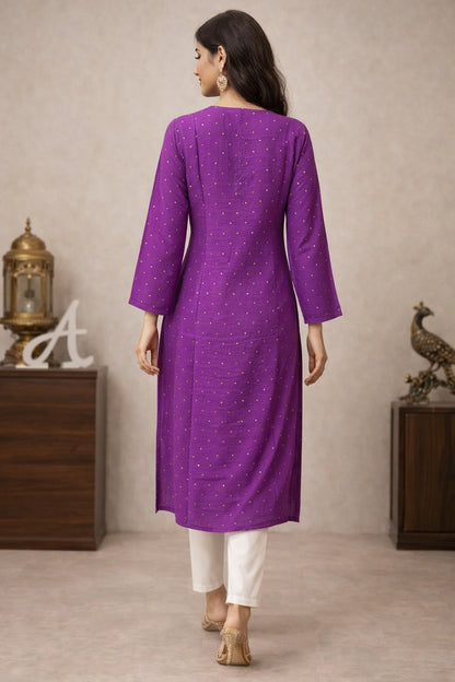 Lucknowi Chikankari A woman is shown from the back wearing a purple long kurta with small gold motifs and white pants, standing in an indoor setting with decorative furniture.