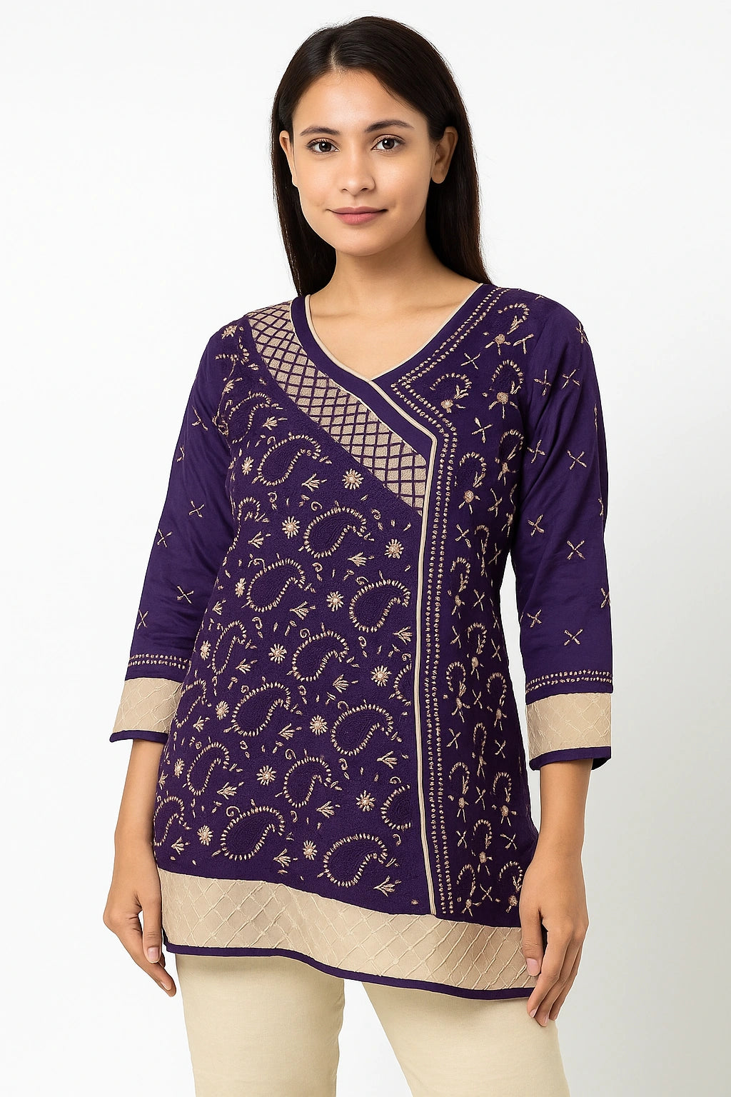 Woman wearing a lucknowi chikankari purple patterned top with beige pants on a white background