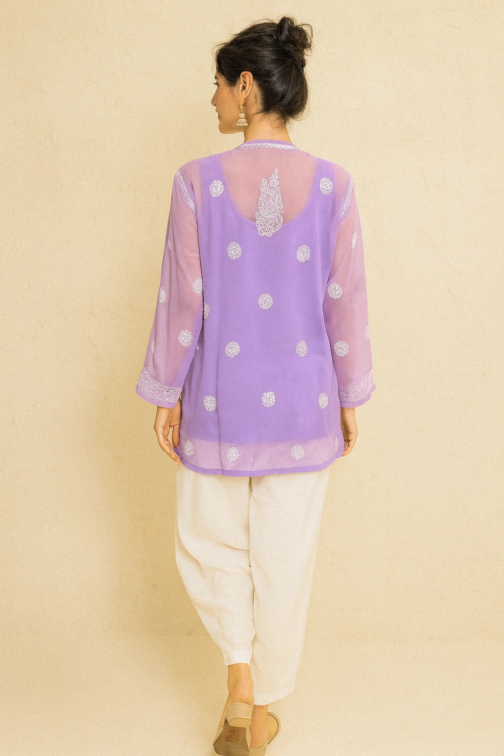 lucknowi chikankari Woman wearing a purple polka dot top with a beige background