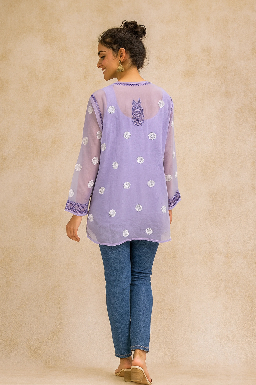 lucknowi chikankari Woman wearing a light purple top with white polka dots and blue jeans on a beige background
