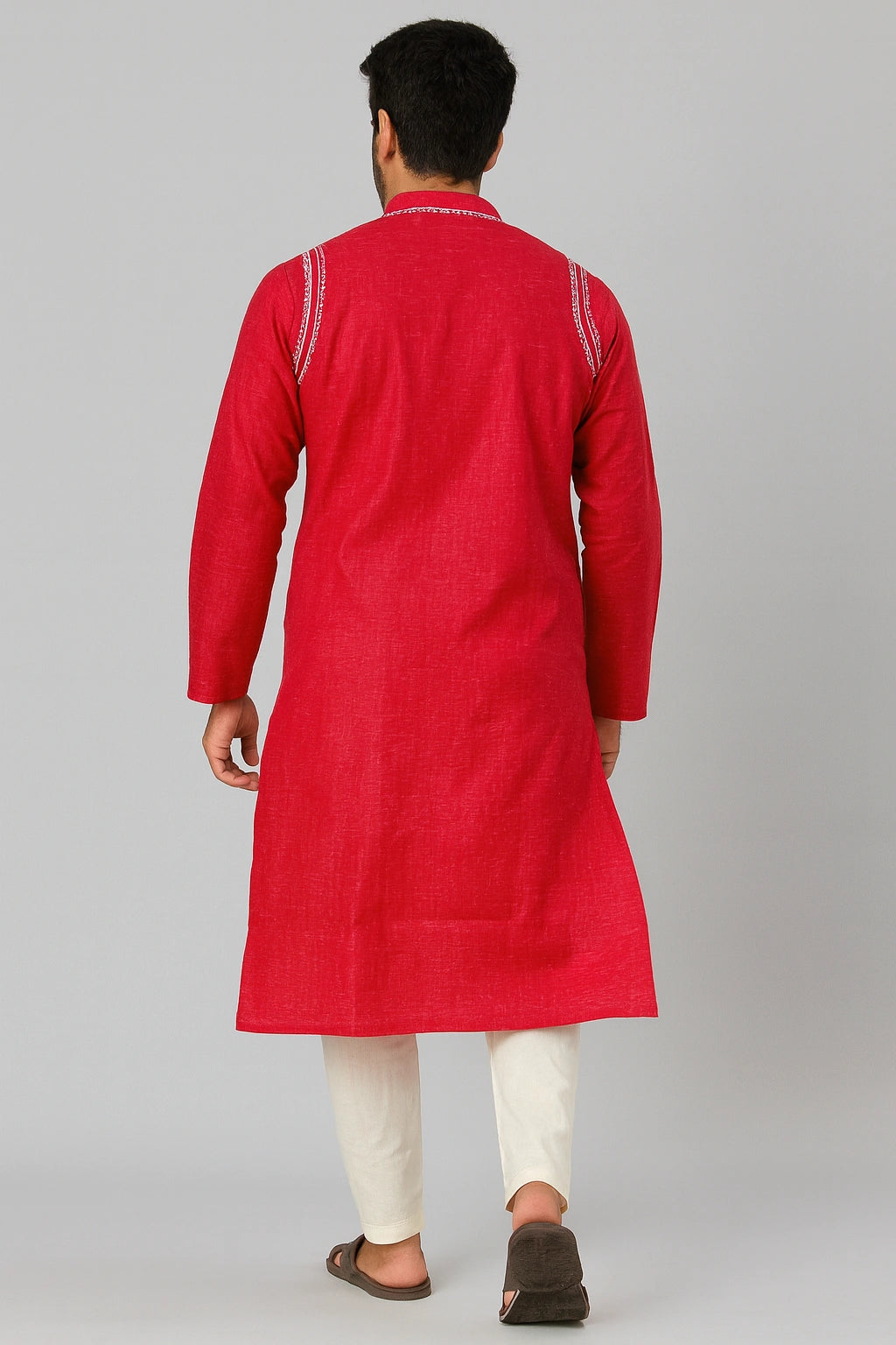 Man wearing a lucknowi chikankari red kurta with white pants on a gray background