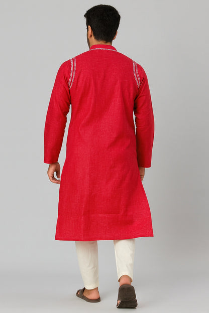 Man wearing a lucknowi chikankari red kurta with white pants on a gray background