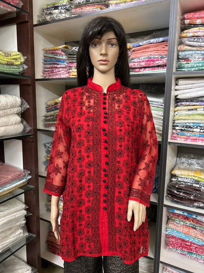 Mannequin wearing a lucknowi chikankari red patterned kurta in a fabric store.