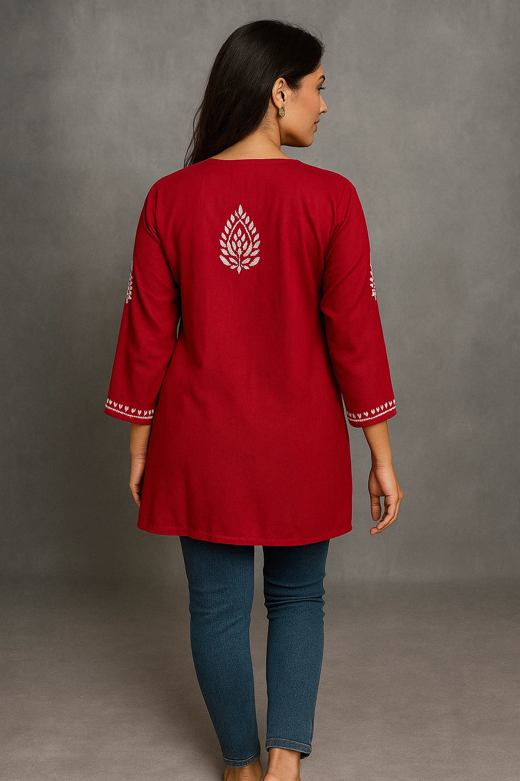 Woman wearing a lucknowi chikankari red kurta with white patterns on a gray background