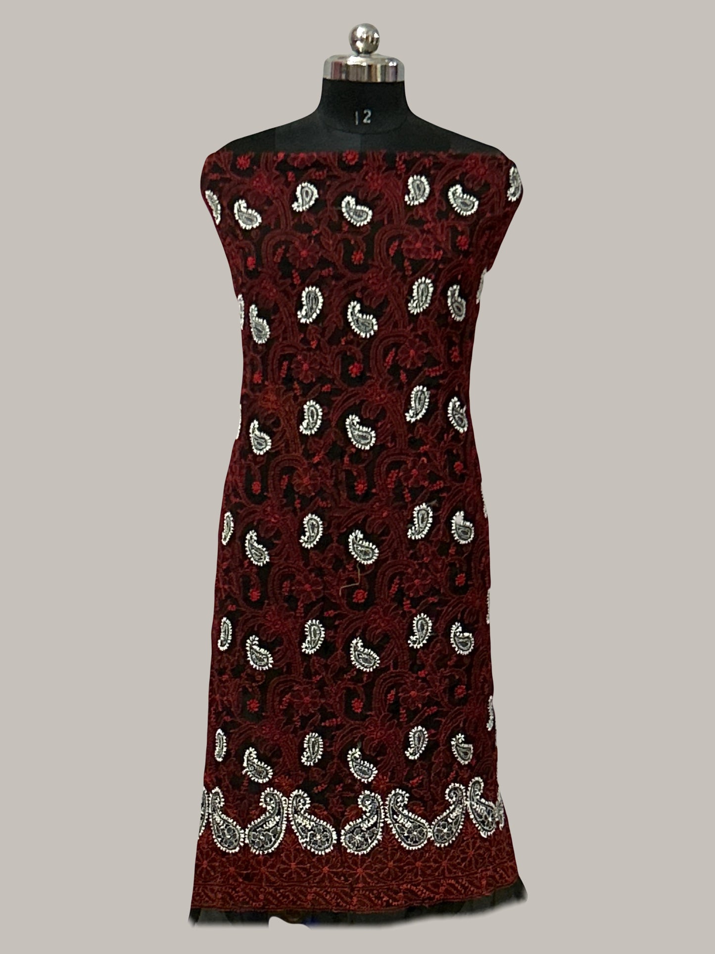 lucknowi chikankari Red dress with white floral pattern on a mannequin against a gray background