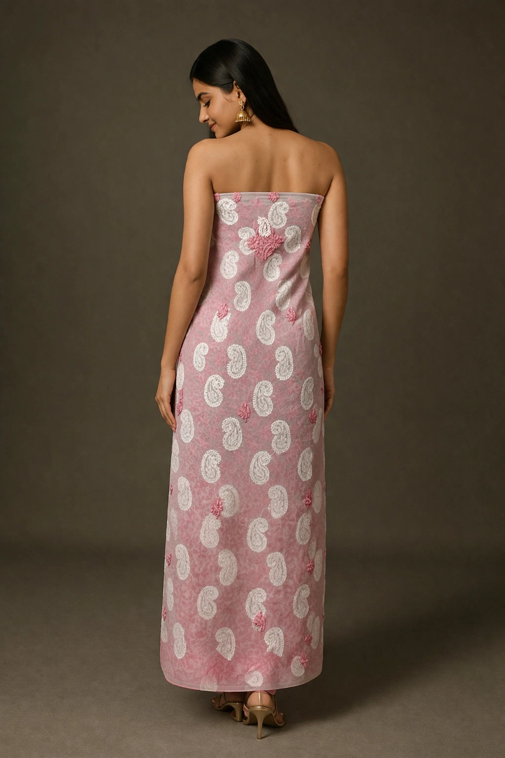 Woman wearing a lucknowi chikankari strapless dress with a floral pattern on a brown background