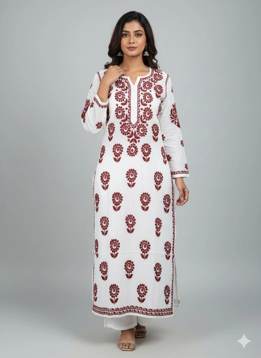 Woman wearing a lucknowi chikankari white dress with red floral patterns on a gray background
