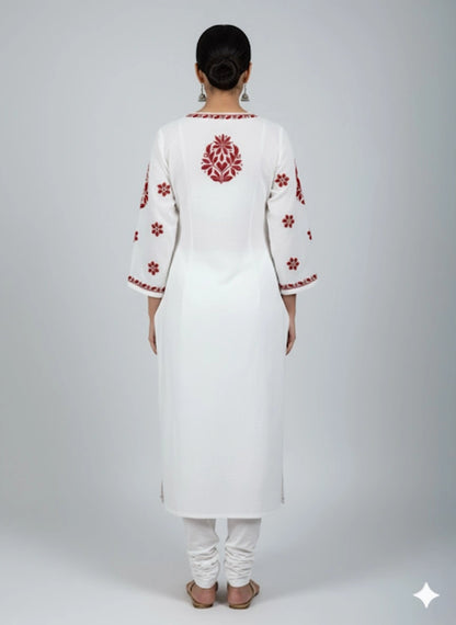 White kurta with red embroidery on a plain background