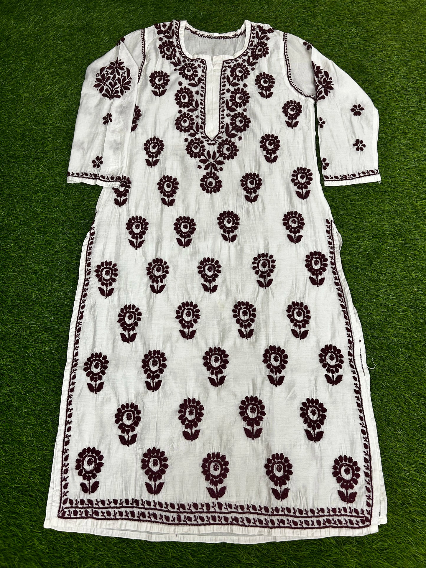 lucknowi chikankariWhite dress with black floral patterns on a green background