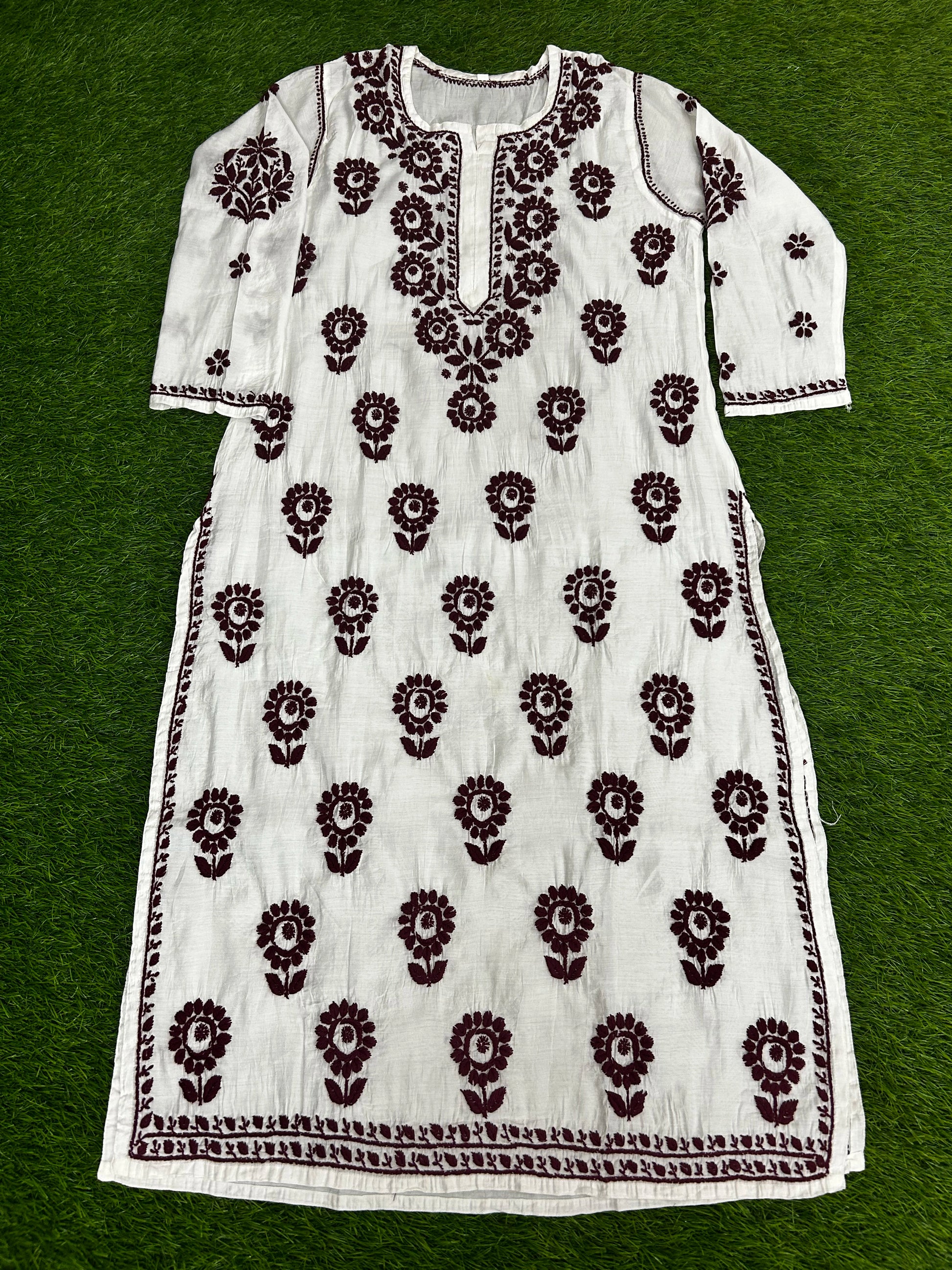 lucknowi chikankariWhite dress with black floral patterns on a green background