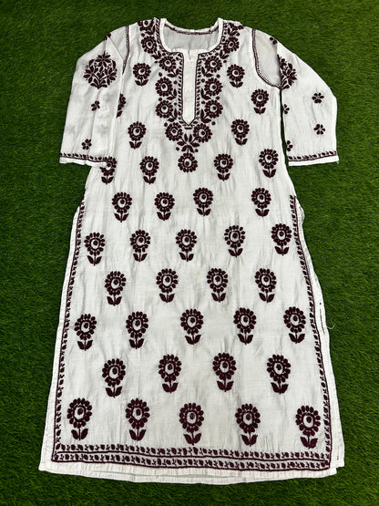 lucknowi chikankariWhite dress with black floral patterns on a green background