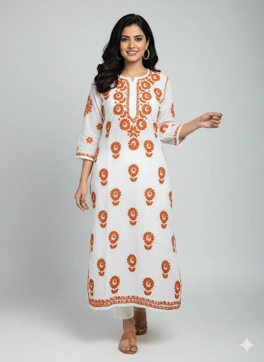Woman wearing a lucknowi chikankari white kurta with orange floral patterns on a gray background