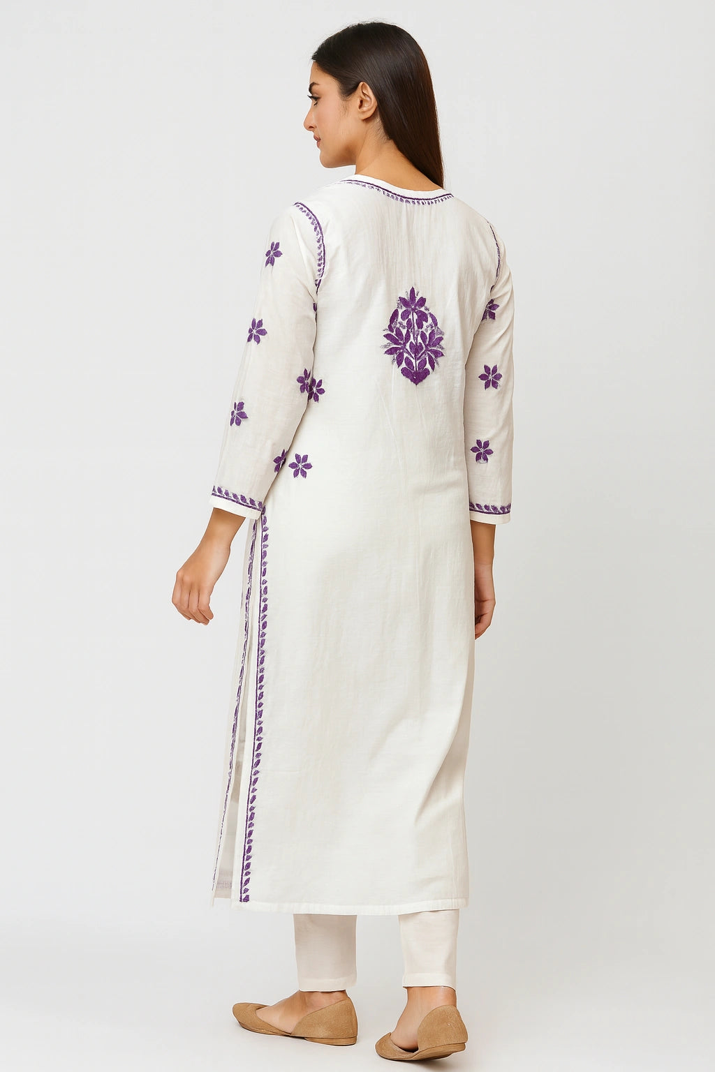 Woman wearing a white kurta with purple floral embroidery on a white background