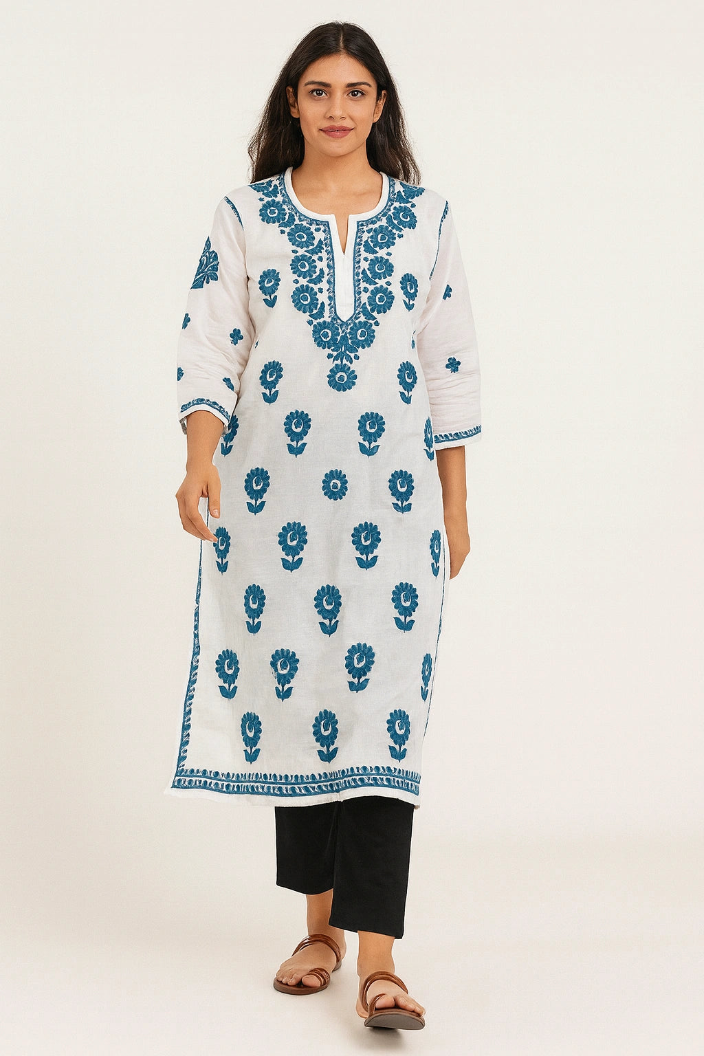 Woman wearing a lucknowi chikankari white kurta with blue floral patterns on a white background