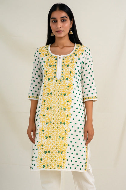 Woman wearing a lucknowi chikankari white kurta with yellow and green floral patterns on a plain background