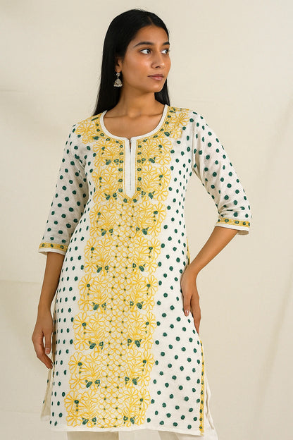 Woman wearing a lucknowi chikankari white kurta with yellow floral patterns on a beige background