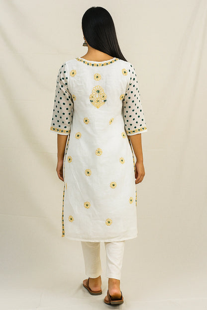 Woman wearing a lucknowi chikankari white kurta with yellow floral embroidery on a plain background