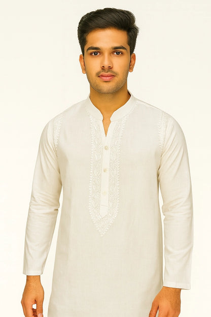 Man wearing a lucknowi chikankari white kurta against a plain background