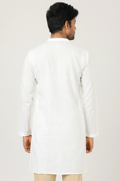 Man wearing a lucknowi chikankari white kurta with beige pants on a light gray background