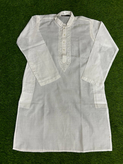 White kurta with intricate embroidery on a green background