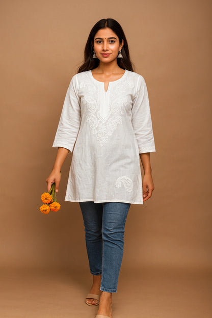 lucknowi chikankari Woman wearing a white kurta with blue jeans against a brown background