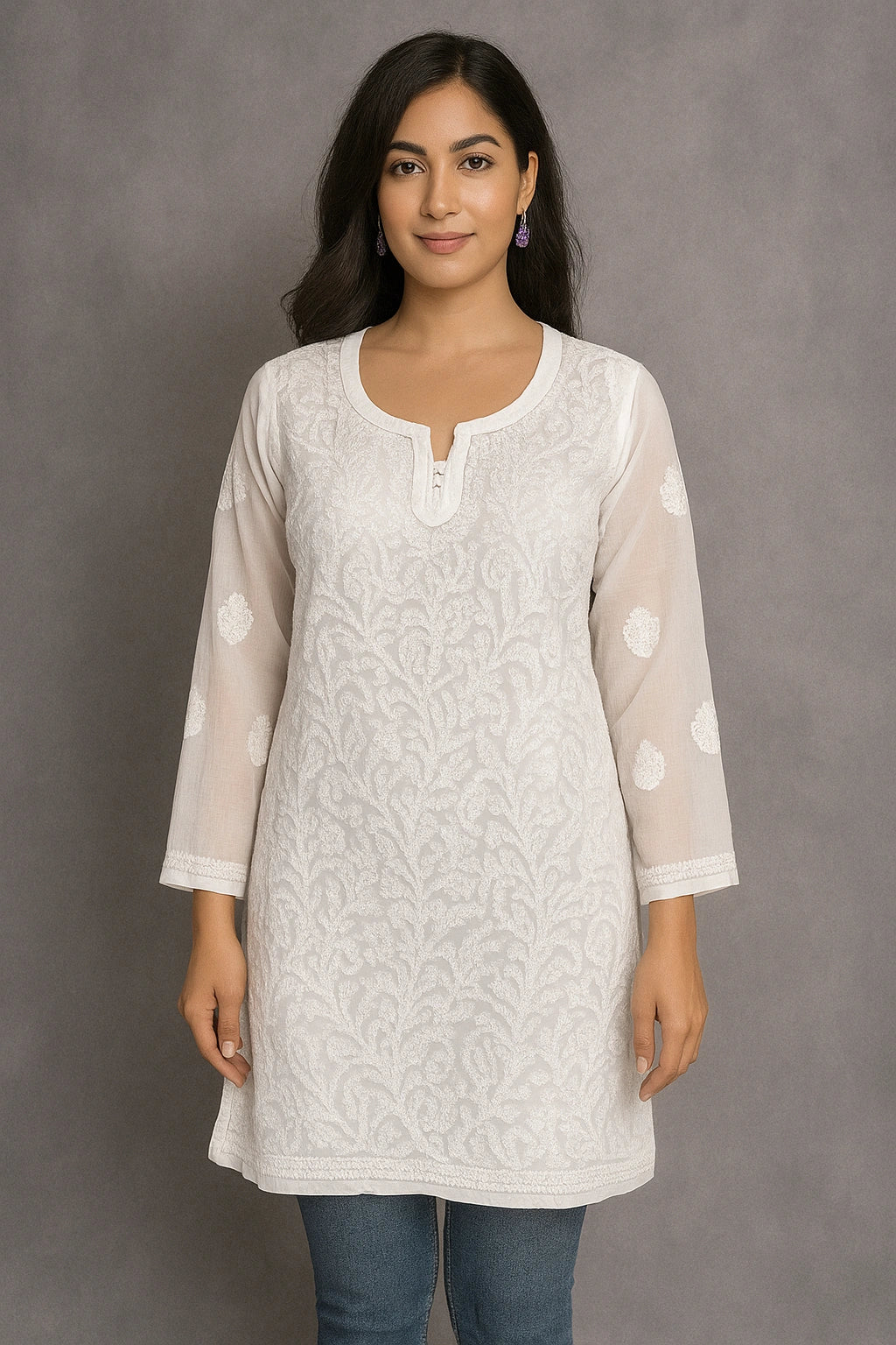 Woman wearing a lucknowi chikankari light-colored floral kurta against a gray background