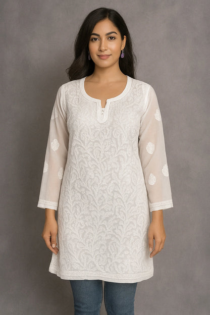 Woman wearing a lucknowi chikankari light-colored floral kurta against a gray background