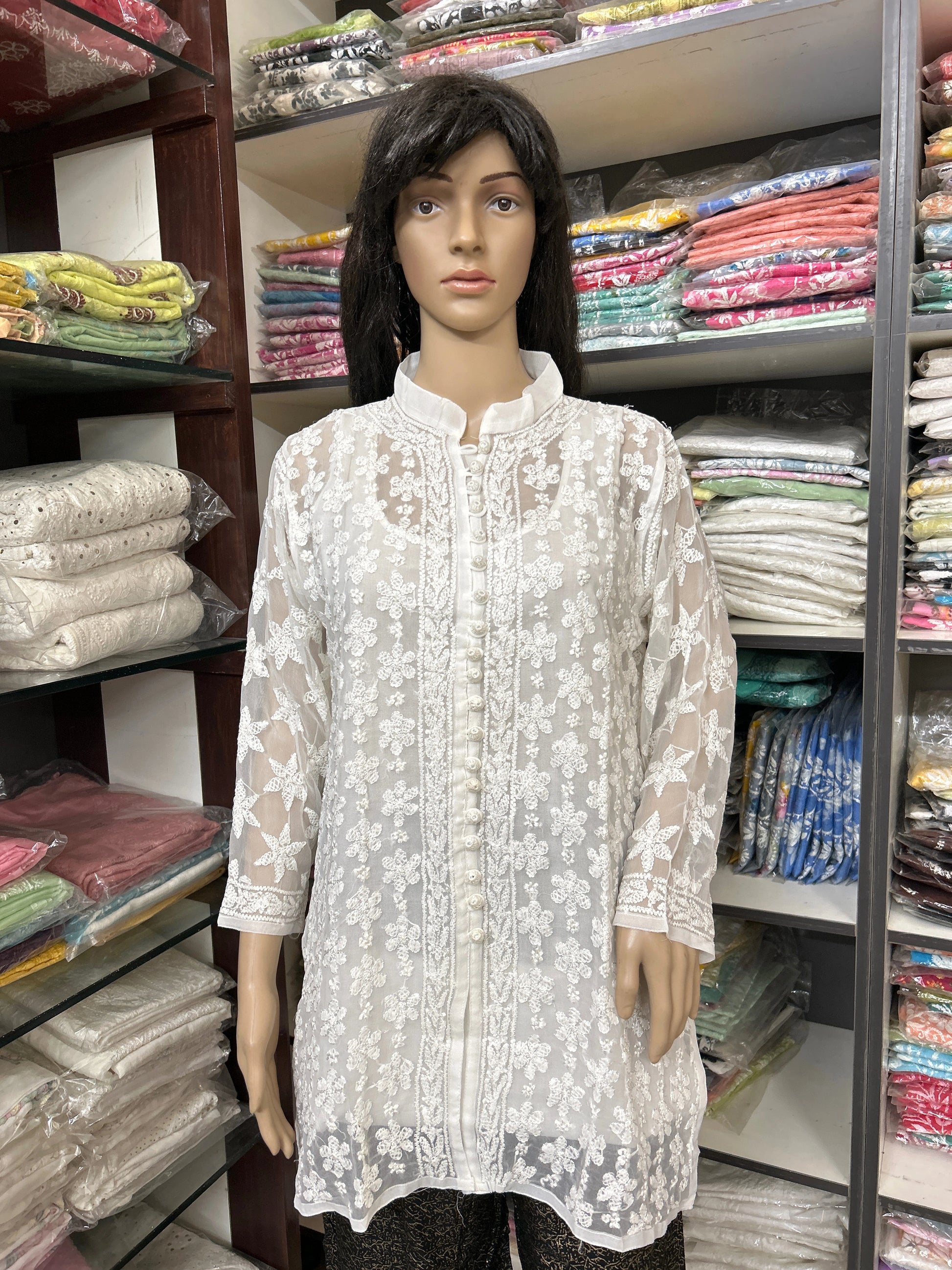 Mannequin wearing a lucknowi chikankari white lace top in a fabric store
