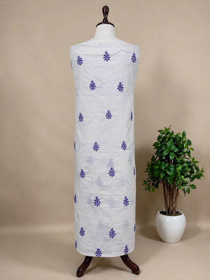 Mannequin wearing a white garment with purple floral patterns against a beige background