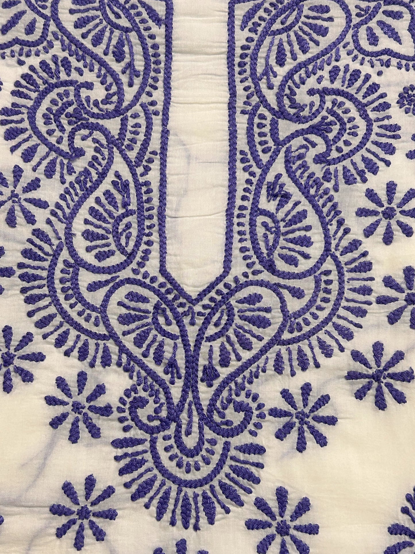 Close-up of blue embroidered pattern on white fabric