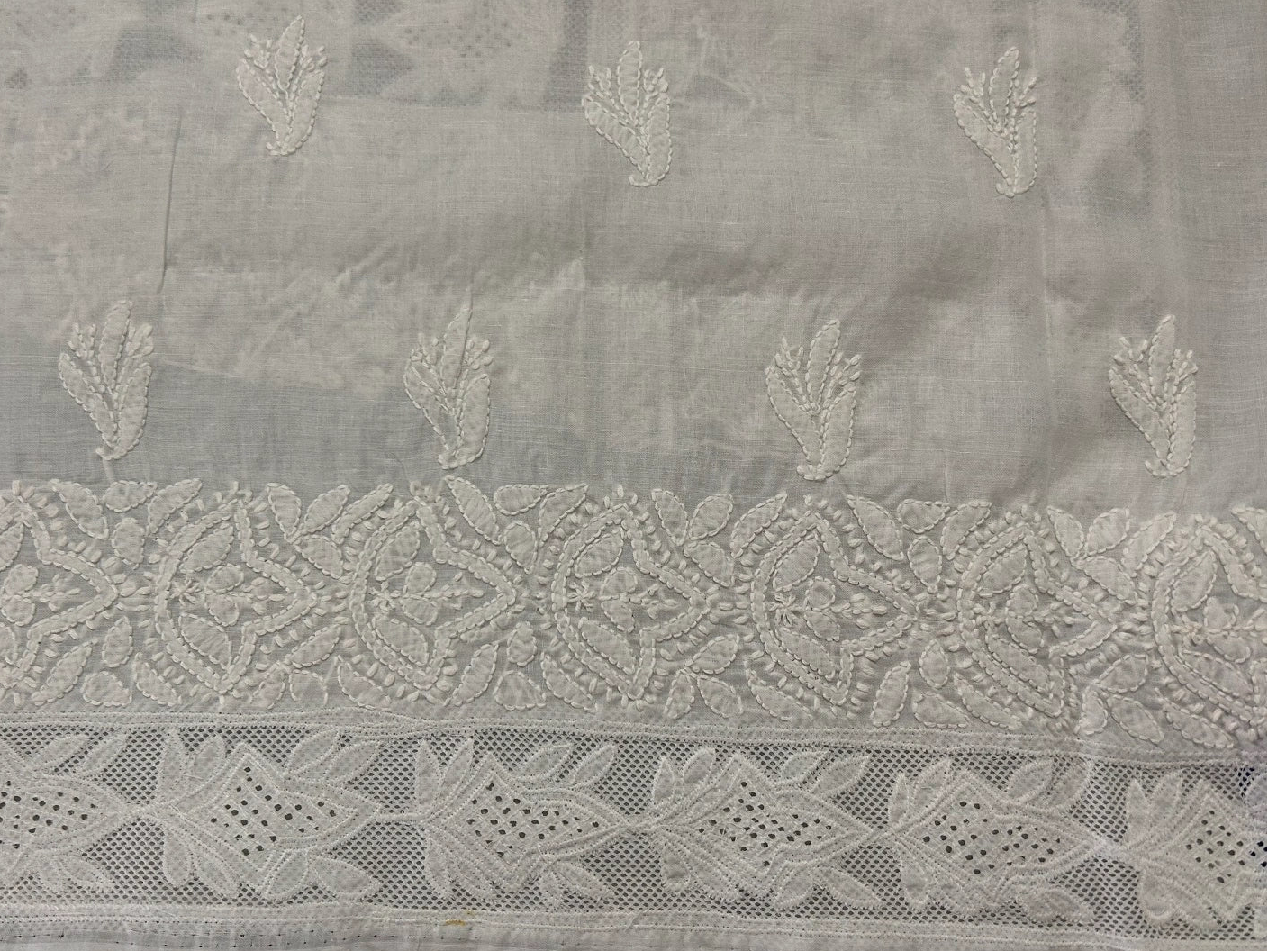 Embroidered fabric with intricate patterns on a gray background