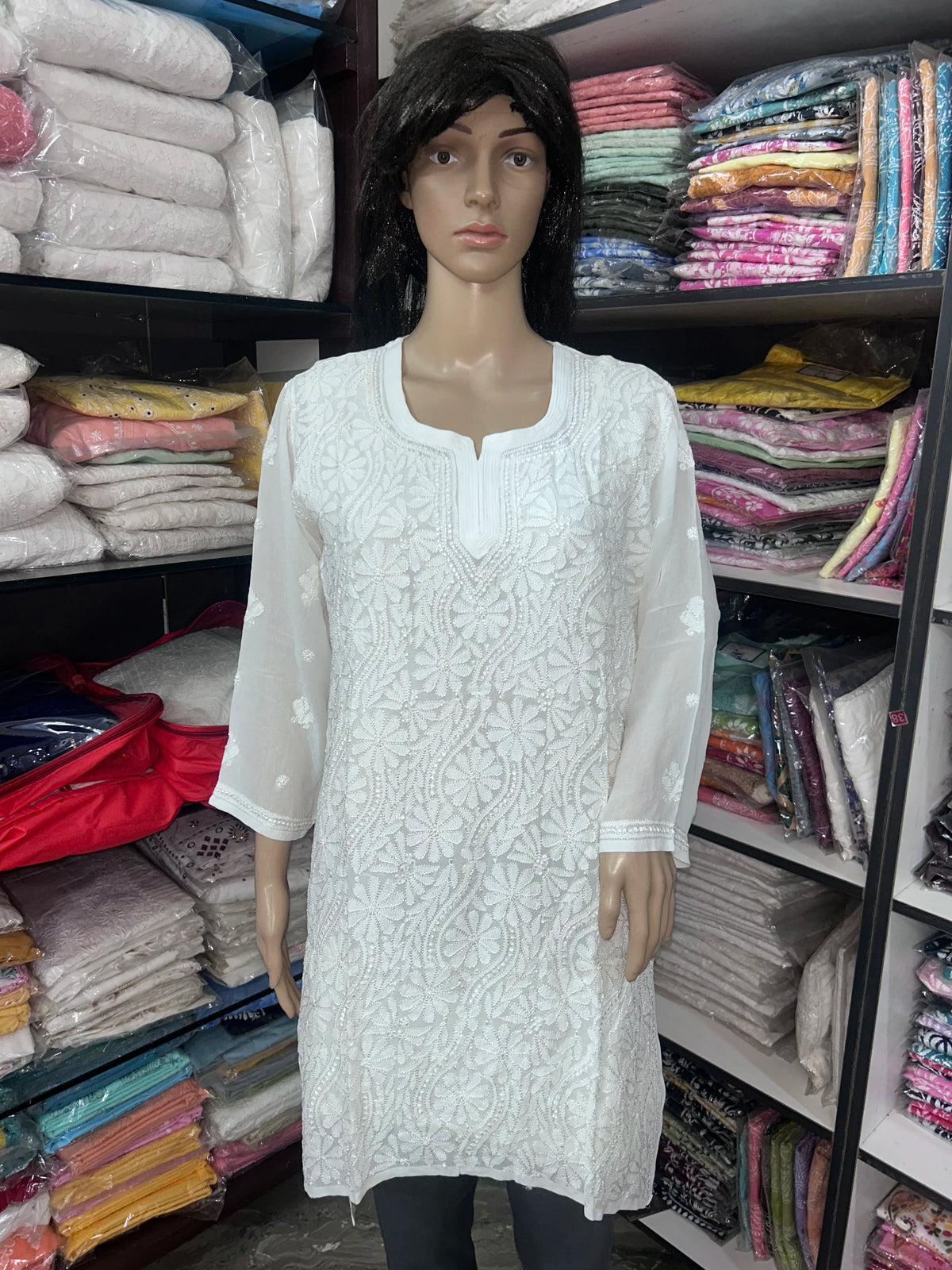 Woman wearing a lucknowi chikankari white-colored kurta with white patterns on a white background
