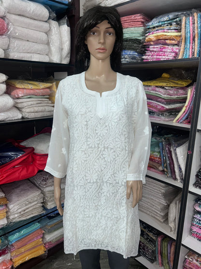 Woman wearing a lucknowi chikankari white-colored kurta with white patterns on a white background